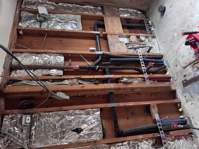 open wall exposing plumbing piping repair work