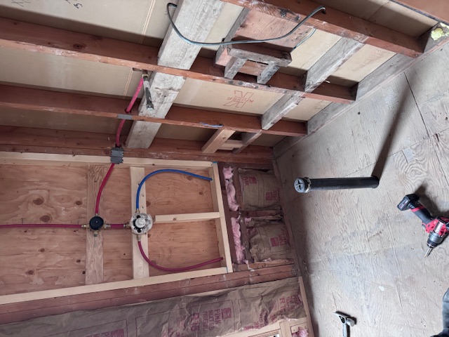 open wall exposing plumbing piping repair work