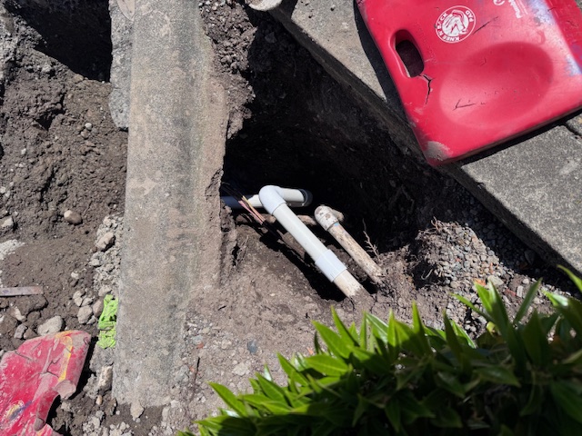 whole in ground with two pipes exposed